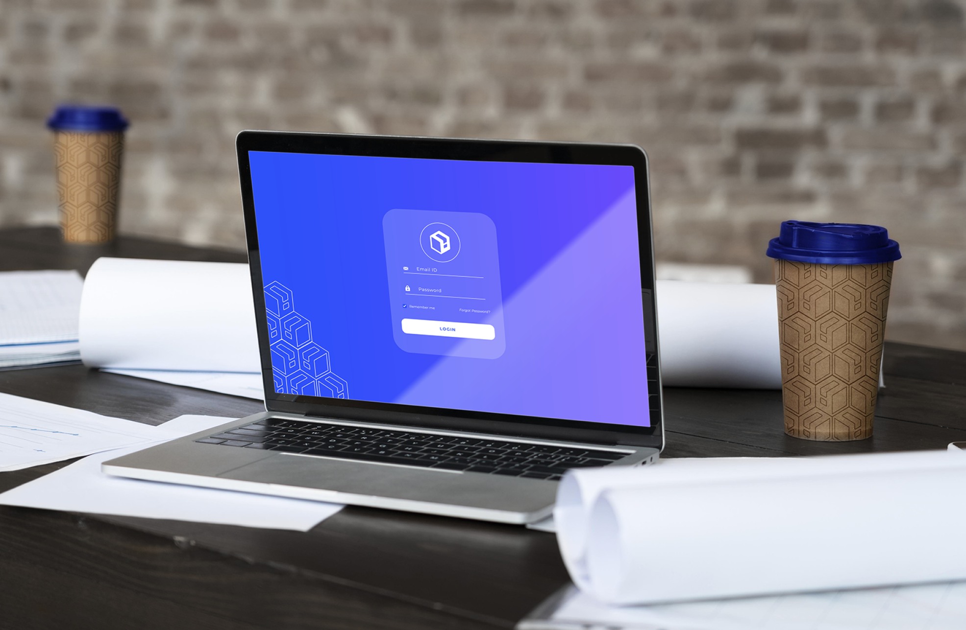 Notebook com a tela de login do sistema Loginfo e copos com a textura da marca
