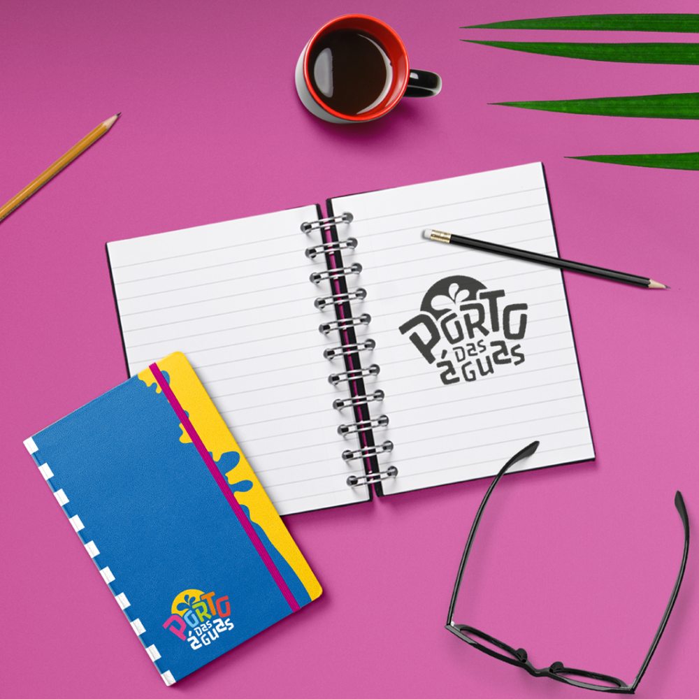 Caderno com capa azul e amarela e o logo aplicado em preto